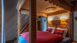 Une pièce en bois avec un lit, un escalier et une lampe fixée au mur.