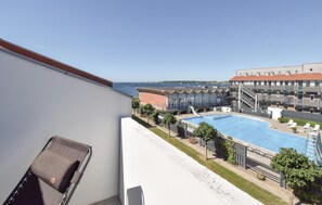 Un hotel con piscina, zona de estar al aire libre y vista al mar.