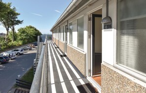 Guest rooms feature large windows with frosted glass designs and access to a tiled corridor with a metal handrail.