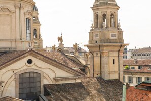 Un edificio histórico con una torre de campanas, ventanas en arco y estatuas.