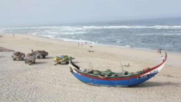 Une plage avec un bateau et quelques rochers.