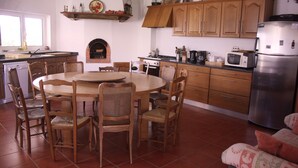 Une cuisine avec des meubles de rangement en bois, une table de salle à manger ronde et des chaises.