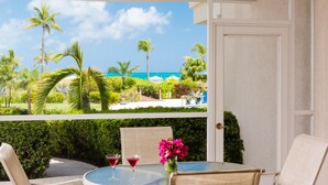 Une chambre avec vue sur un paysage tropical, comprenant des palmiers et une piscine.