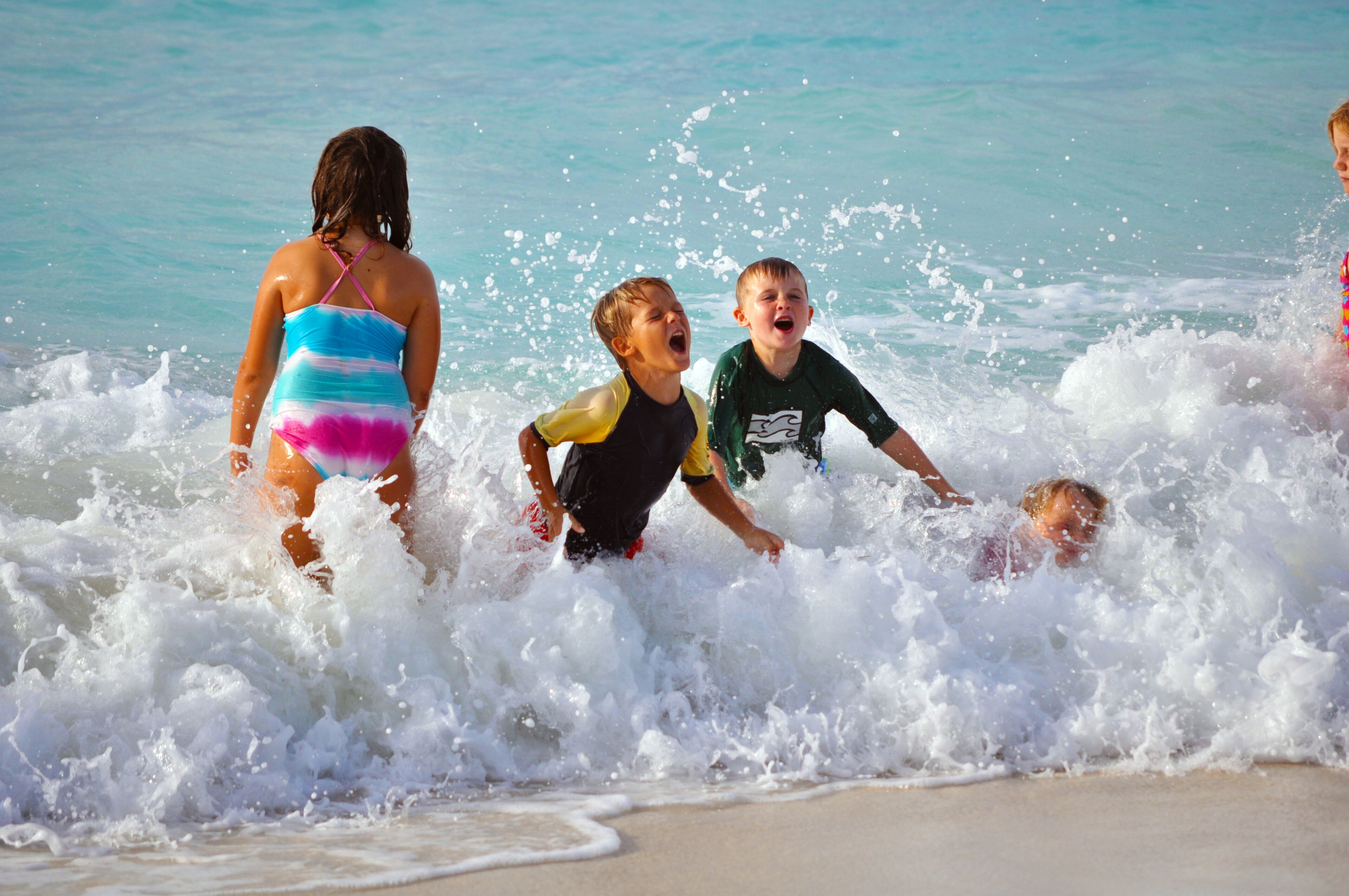 Een strandscène met mensen die in het water spelen.