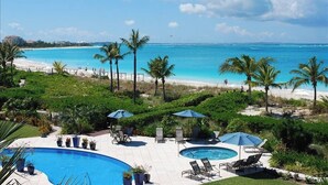 Un espace piscine offrant une vue sur la plage et l’océan.