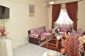 Relax in this cozy living space with a sofa set, coffee table, and mounted TV.