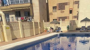 Ein Schwimmbecken mit gefliestem Rand und einer Metallhandstange.