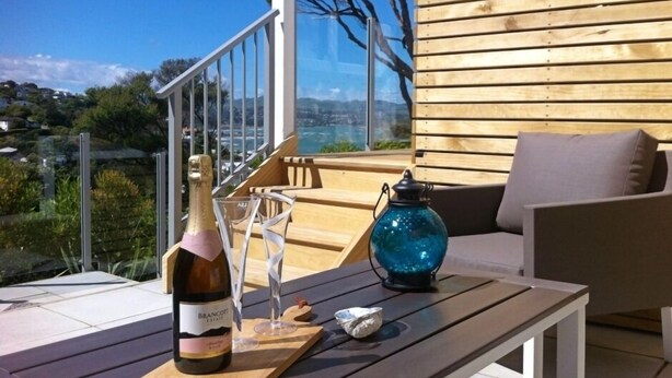 A wooden deck with a table, a bottle of Brancott wine, and a glass.