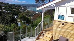 A wooden staircase leading to a deck with a view of a coastal town.