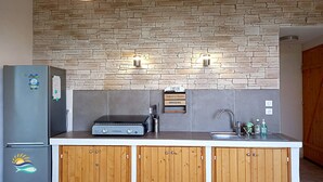 A compact kitchen with a stone backsplash, a built-in grill, and wooden cabinets. - Charming villa with private pool and summer kitchen ♥ Near Calanques (Ceyreste)