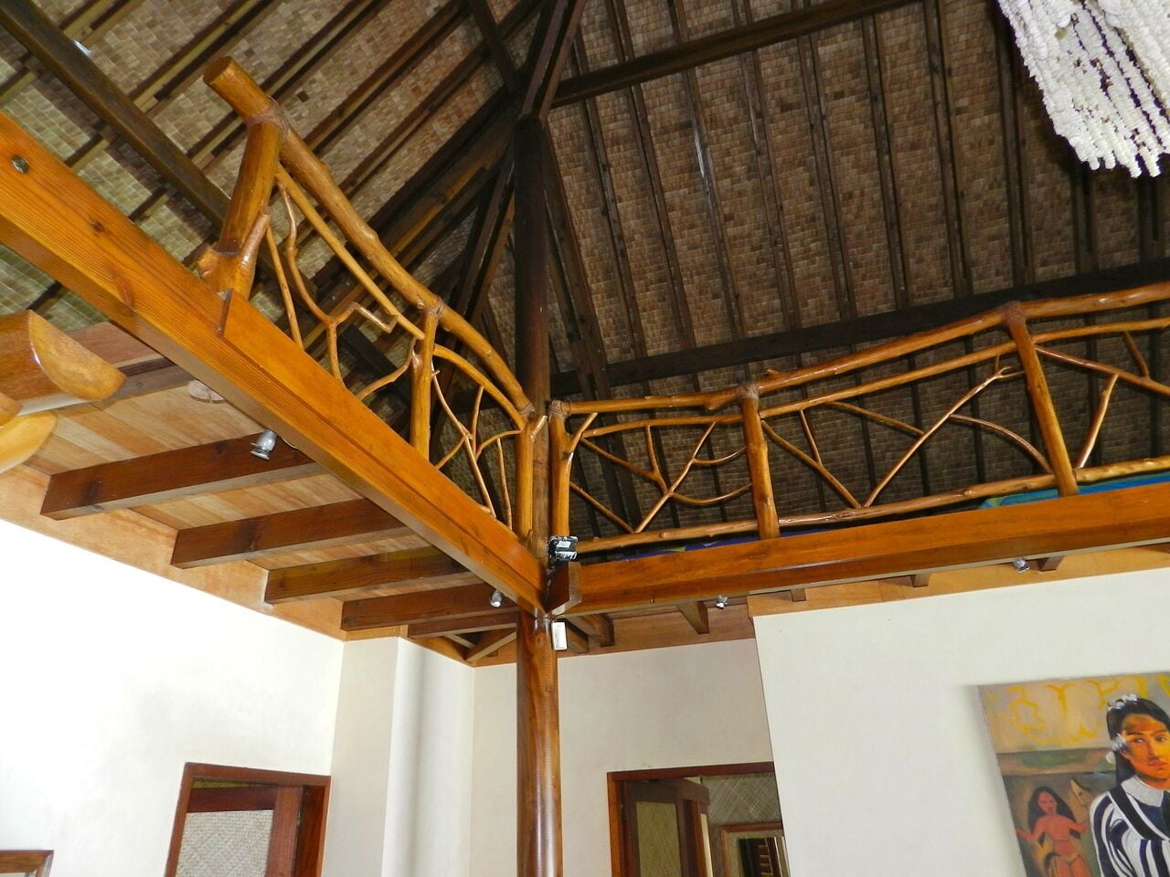 A wooden staircase with a thatched roof ceiling.