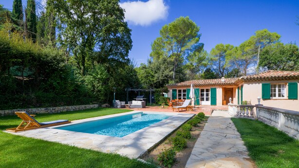 A pool with a stone deck, a lawn, and a house with green shutters. - Valbonne Quiet villa with magnesium pool (Valbonne)