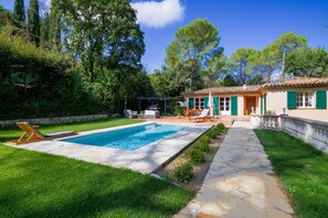 A pool with a stone deck, a lawn, and a house with green shutters. - Valbonne Quiet villa with magnesium pool (Valbonne)