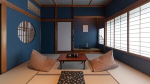 A traditional Japanese room with tatami flooring, a shoji screen, and a low table with cushions. - Hinaya Higashiyama (Kanazawa)