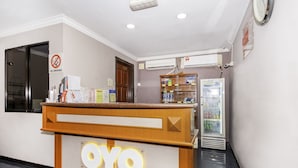 A reception desk with a 'NO SMOKING' sign, a clock, and a refrigerator with beverages. - Super OYO 473 Comfort Hotel 2 (Klang)