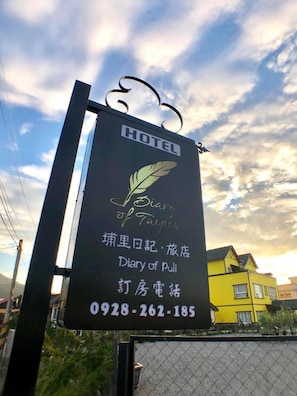 A hotel sign with the name 'Diary of Puli' and a contact number. - Puli Diary (Puli)