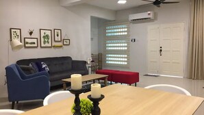A modern living room with a sofa, a dining table, and a ceiling fan. - Sandakan Hill Terrace 3 (Sandakan)
