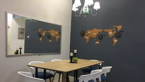 A conference room with a wooden table, white and blue chairs, a world map on the wall, and a chandelier. - Sandakan Hill Terrace 3 (Sandakan)