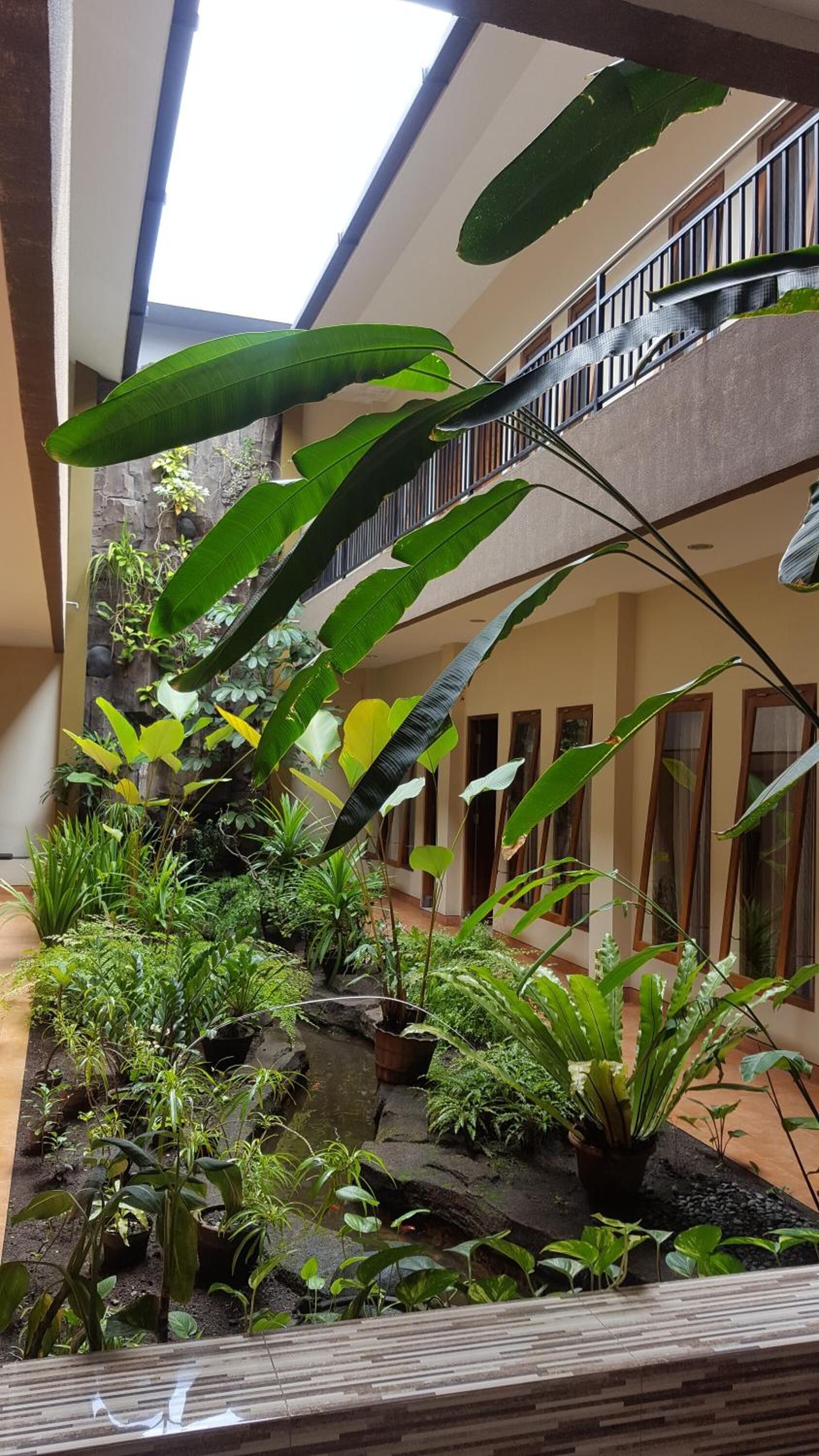 A multi-level atrium with a water feature and various plants.