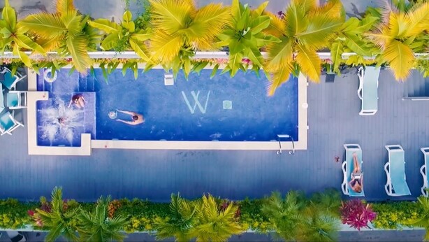 Una piscina techada, una piscina al aire libre, sombrillas