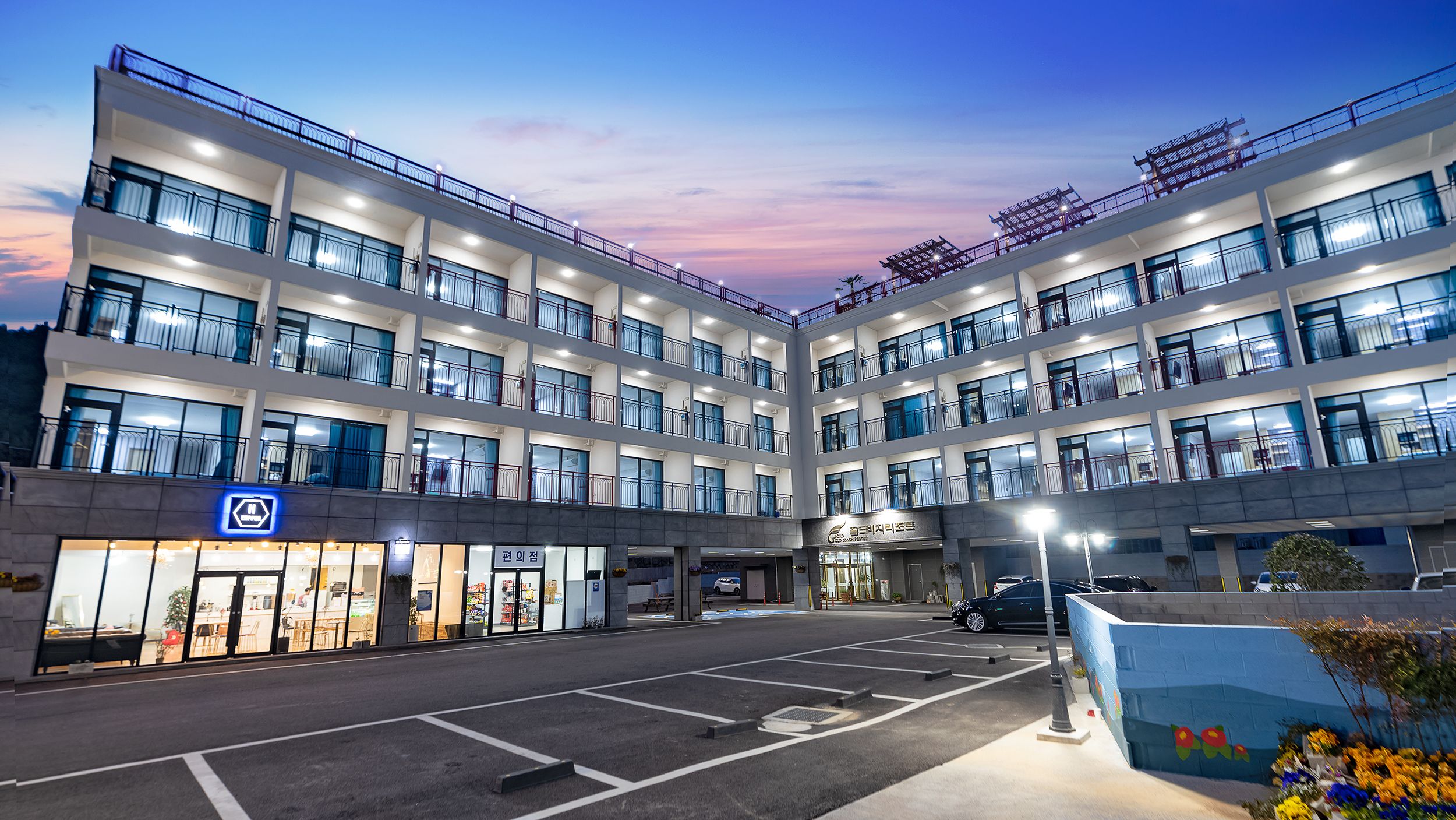 A multi-story hotel with a central courtyard, multiple balconies, and a variety of shops on the ground floor.
