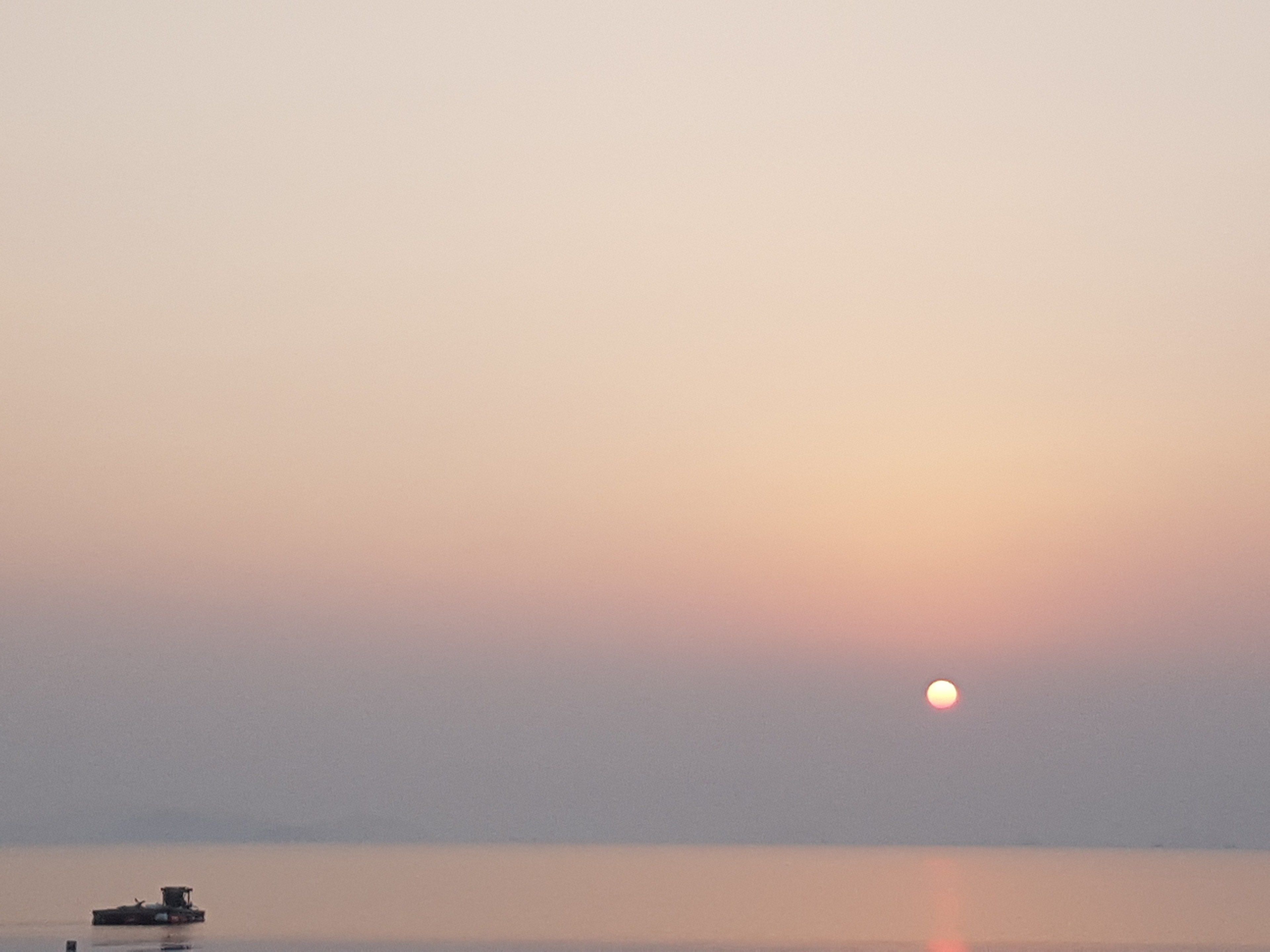 A boat on calm water during sunset.