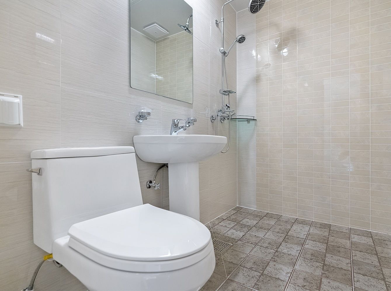A modern bathroom with a toilet, sink, and shower.