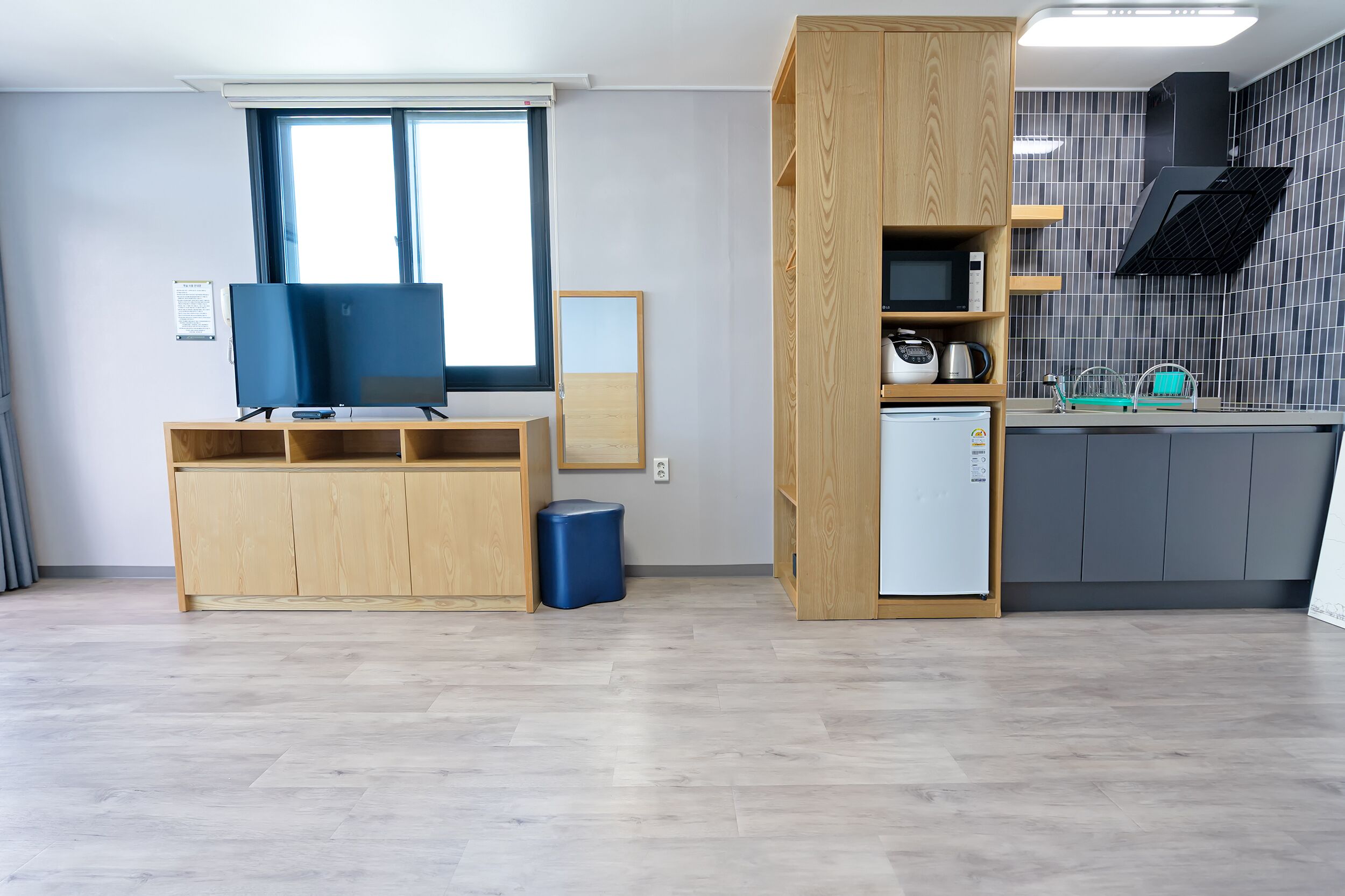 A compact living space with a kitchenette, a TV, and a small dining area.