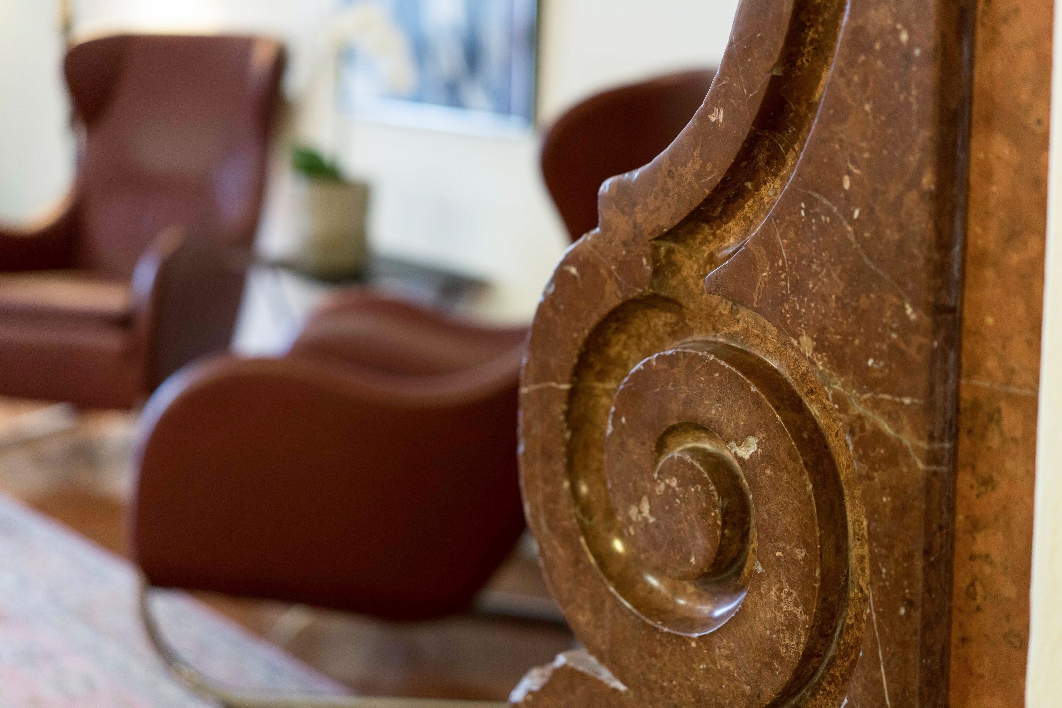 A close-up of a wooden column with a carved spiral design, part of a room's interior.