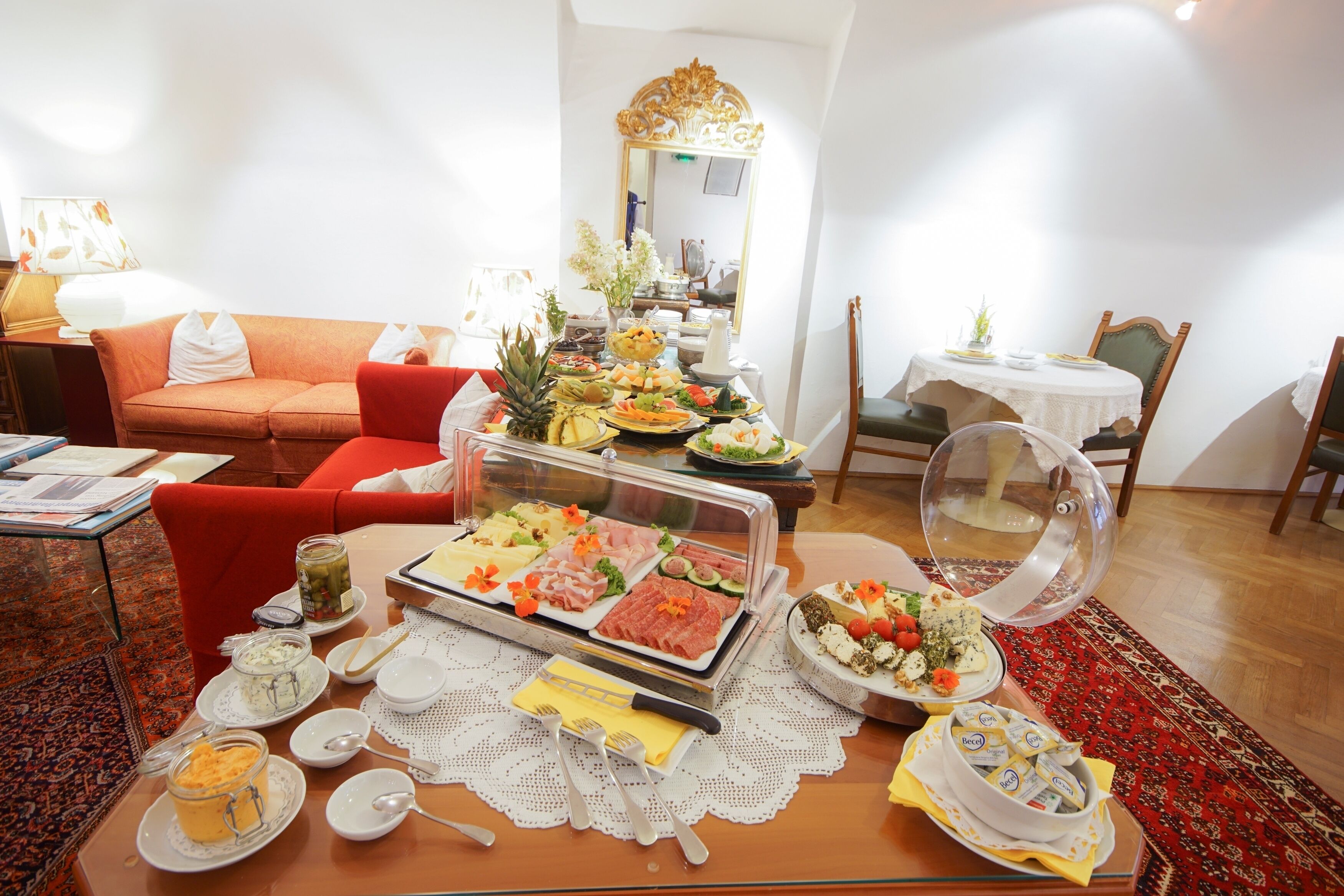 Una mesa de buffet con diversos alimentos y un expositor de vidrio.