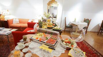 Una mesa de buffet con diversos alimentos y un expositor de vidrio.