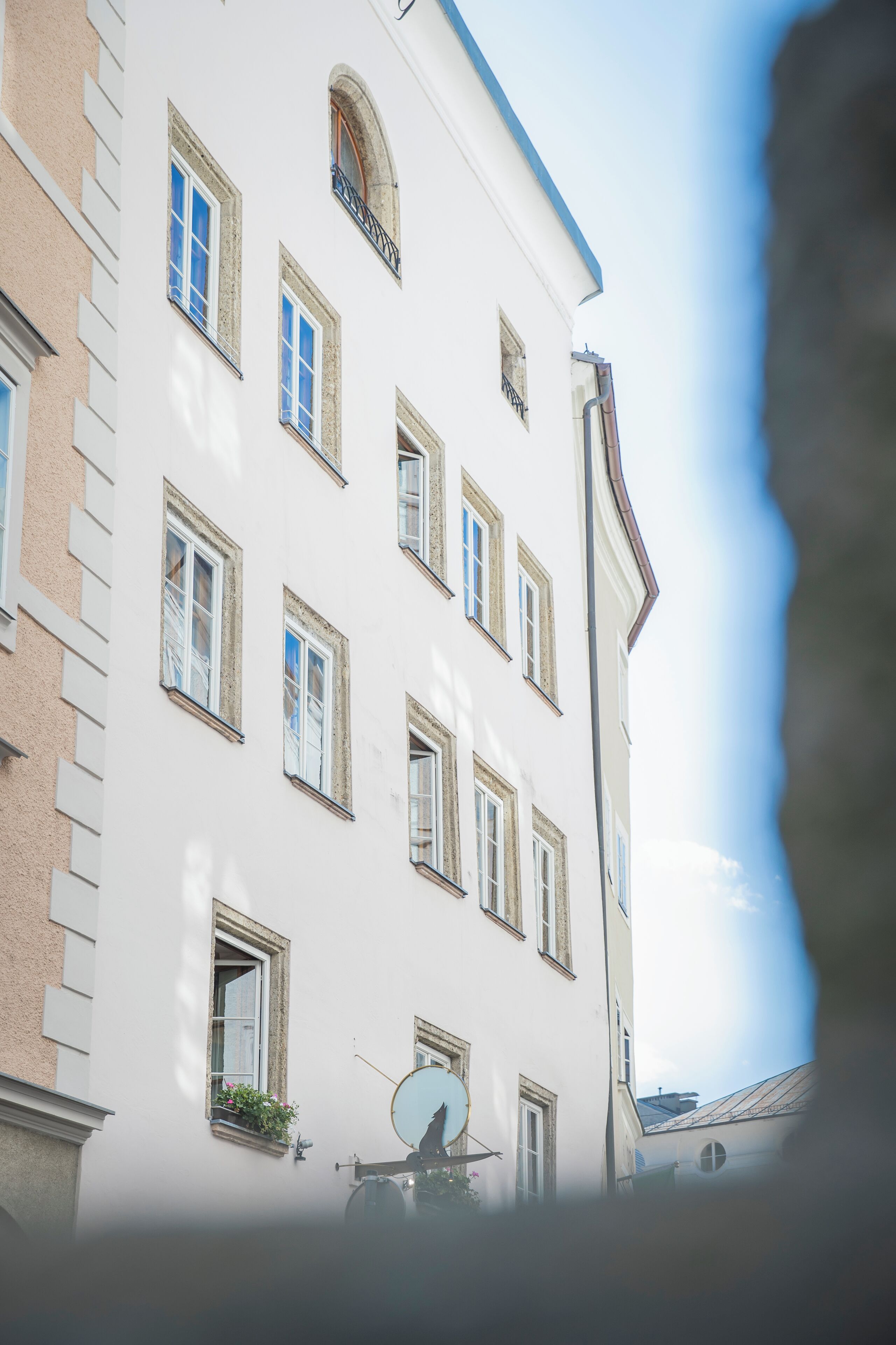 Ein mehrstöckiges Gebäude mit weißen Wänden und zahlreichen Fenstern.