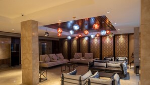 A modern lobby with a seating area, a reception desk, and patterned walls. - Hotel Span International (Kanayannur)