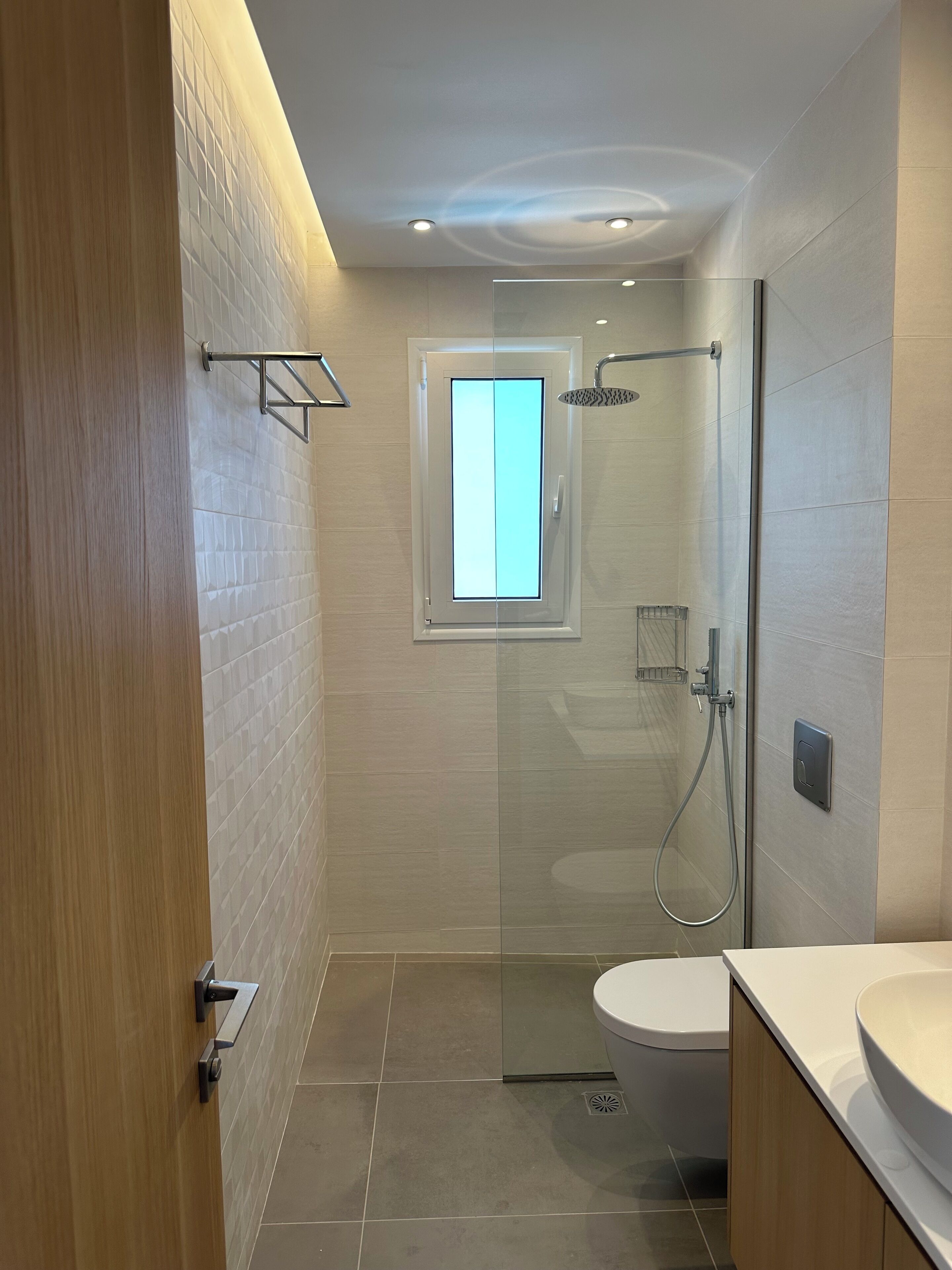 Une salle de bain moderne avec une douche à parois de verre, des toilettes et un lavabo.