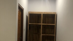 A hallway with a wooden wardrobe and a door. - Cantika Guest House (Pecatu)