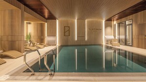 A modern indoor swimming pool with a wooden interior, a glass wall, and a sign reading 'PLATINUM hotel & spa'. - PLATINUM hotel & spa (Sarajevo)