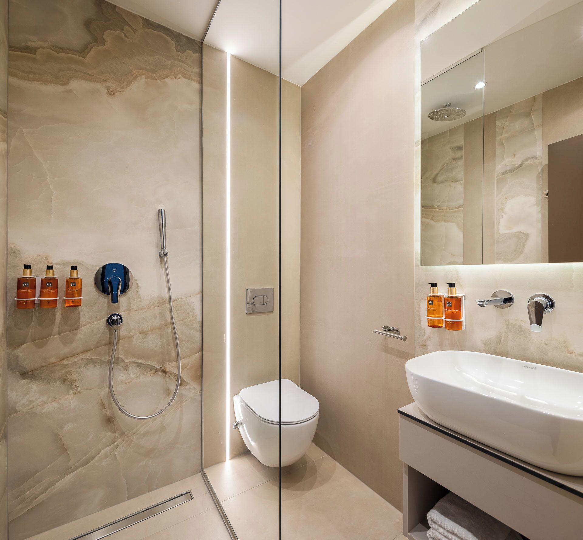 A modern bathroom with a glass-enclosed shower, a toilet, and a vanity with a sink.