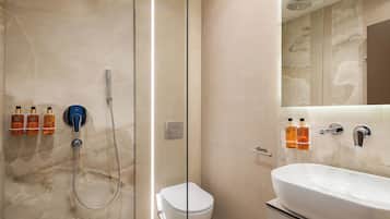 A modern bathroom with a glass-enclosed shower, a toilet, and a vanity with a sink.