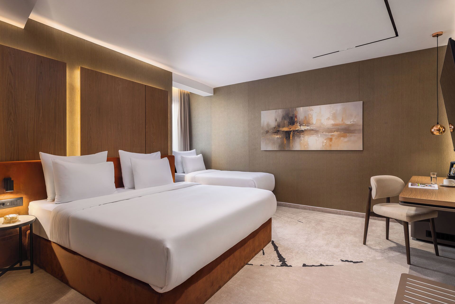 Ein modernes Hotelzimmer mit einem großen Bett, einem Schreibtisch und einem Stuhl.