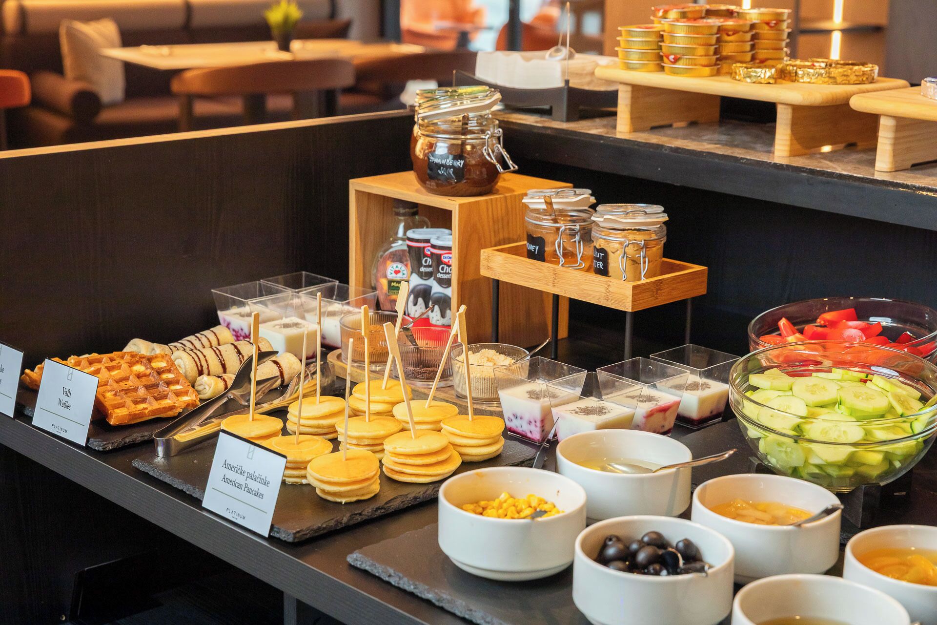 A buffet with various food items including waffles, pancakes, and a selection of fruits and vegetables.