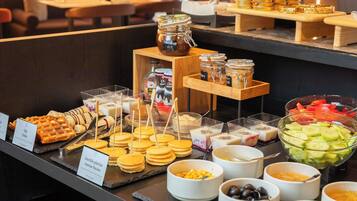 A buffet with various food items including waffles, pancakes, and a selection of fruits and vegetables.
