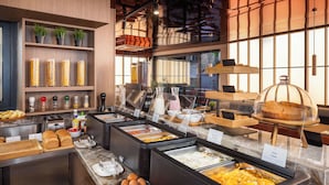 A buffet setup with various food items and condiments. - PLATINUM hotel & spa (Sarajevo)