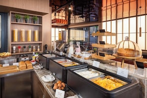 A buffet setup with various food items and condiments.