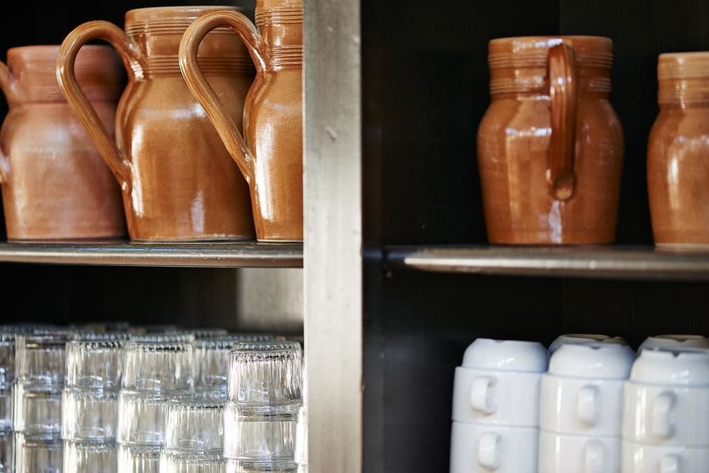 Estantes con tazas de cerámica y cristalería.