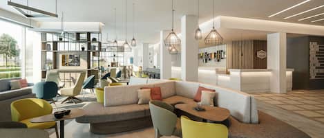 A modern hotel lobby with a sectional sofa, colorful chairs, and pendant lighting.