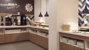 A modern kitchen with a coffee machine, a kettle, and a microwave. There are shelves with plates and cups, and a sign that says "Happy Mind, Happy Life."
