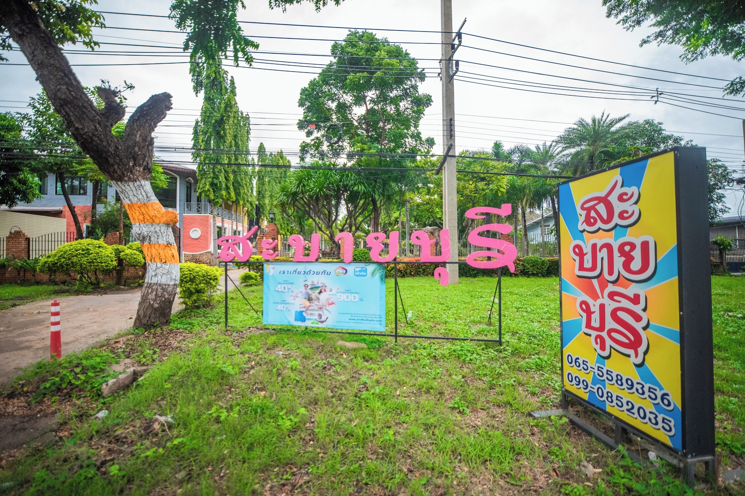 A sign with Thai text and a colorful advertisement.