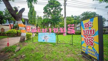 A sign with Thai text and a colorful advertisement.