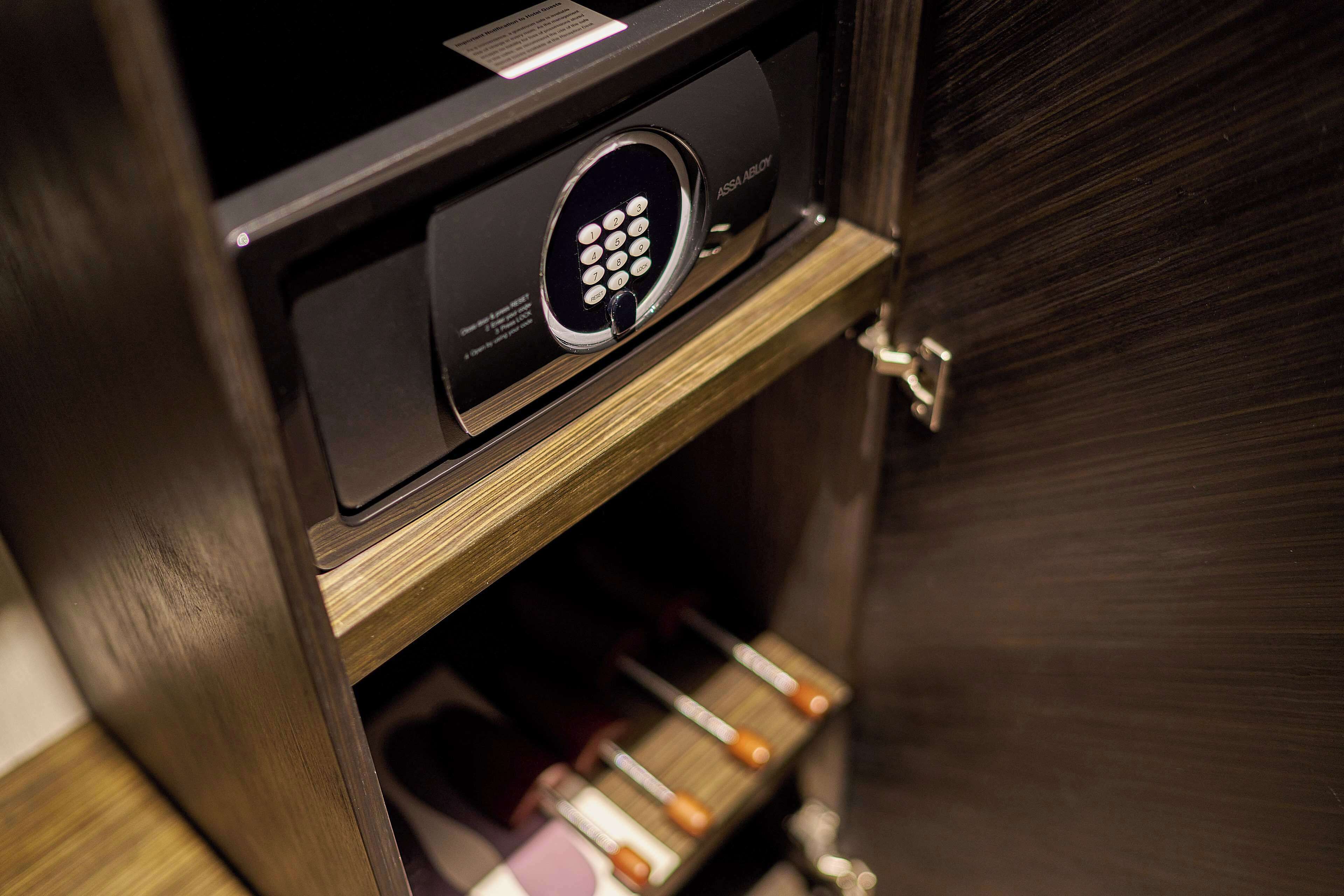 A secure electronic lock with a keypad, a wooden cabinet, and a wine rack with bottles.