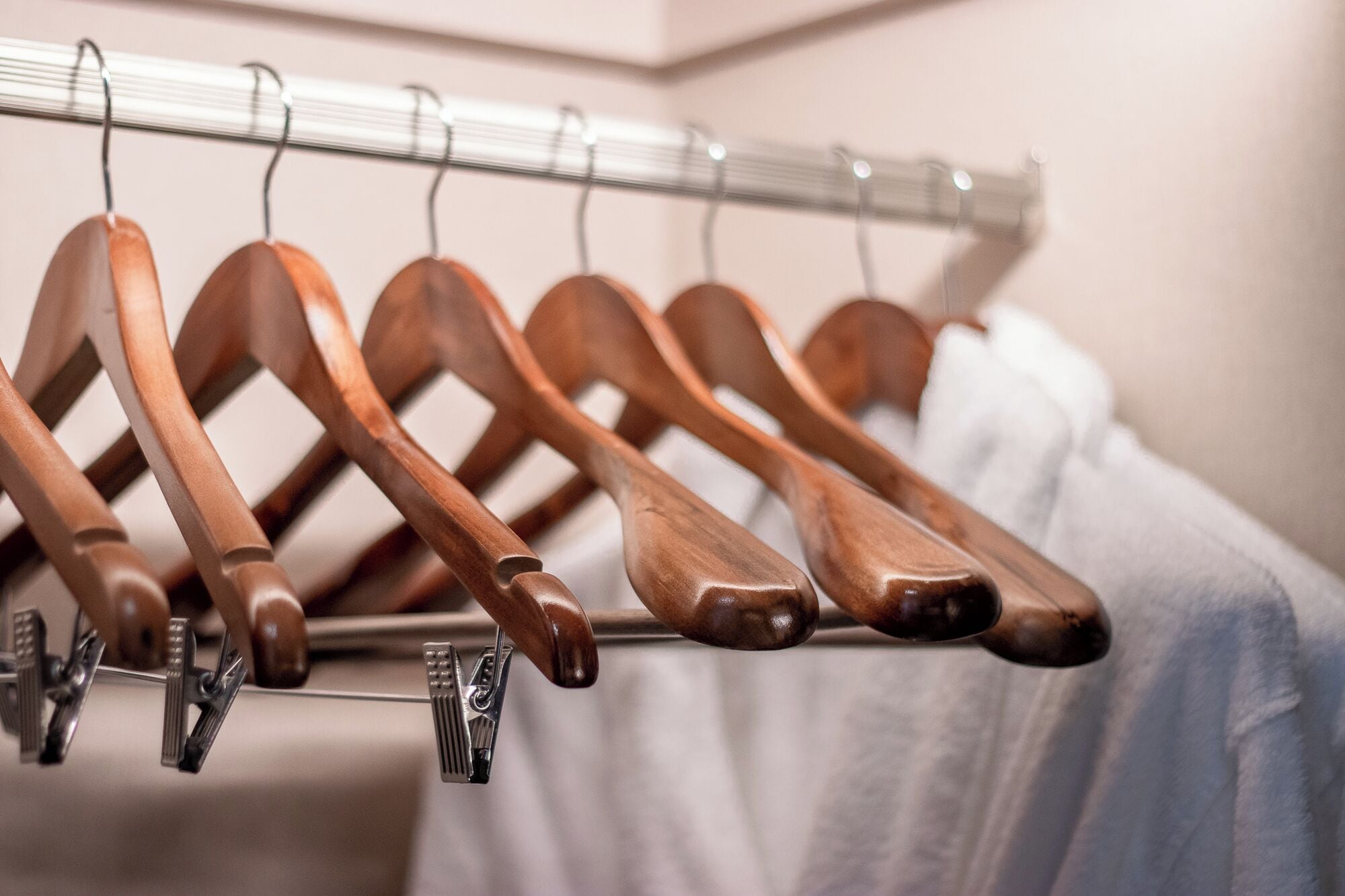 A rack of wooden hangers in a hotel room.